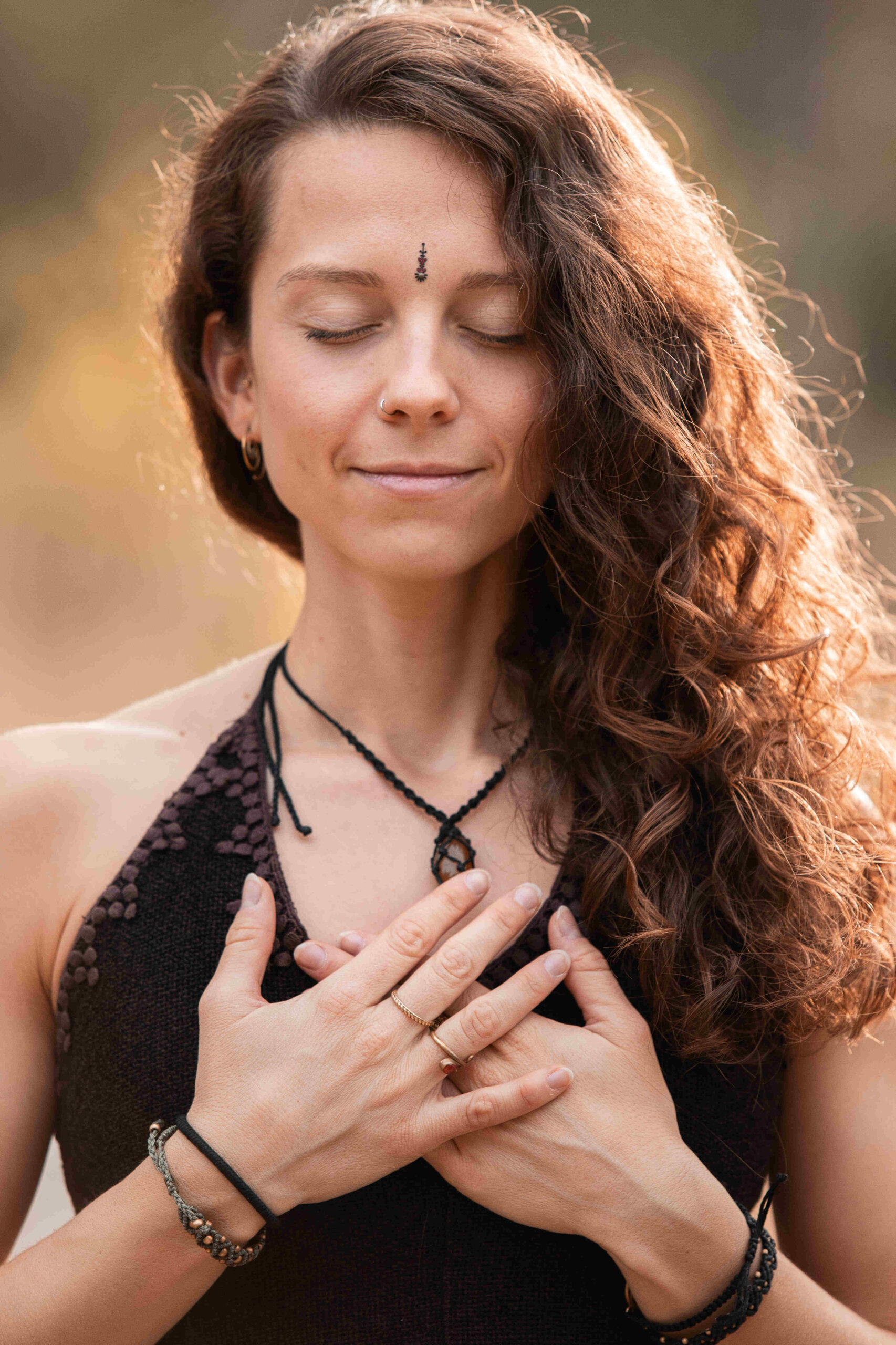 Frau mit Händen auf dem Herzraum und in tiefer Verbindung mit sich selbst
